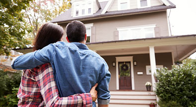 Couple standing in front of a home